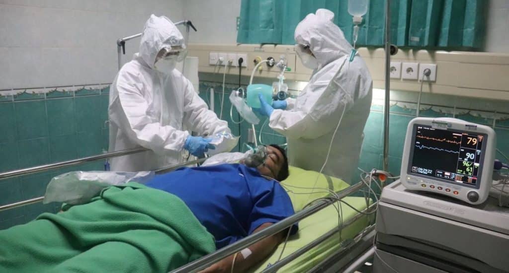 man in white medical scrub lying on hospital bed